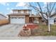 Charming two-story home with a well-manicured front yard, large tree, and brick accents near the mailbox at 9777 W 75Th Way, Arvada, CO 80005