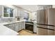 Updated kitchen featuring stainless steel appliances, light gray cabinets, stylish backsplash, and modern fixtures at 9777 W 75Th Way, Arvada, CO 80005