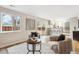 Comfortable seating area with chairs near large window and a slider that leads to the backyard, with view into kitchen at 9777 W 75Th Way, Arvada, CO 80005