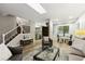 Bright living room with hardwood floors, staircase, a comfortable sitting area and view into the dining room at 9777 W 75Th Way, Arvada, CO 80005