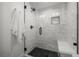 Modern bathroom featuring a tiled shower with glass door, black fixtures, and a built-in bench at 451 S Franklin St, Denver, CO 80209