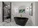 Bright bathroom featuring a modern black soaking tub, mosaic tile floor and a glass-enclosed shower at 451 S Franklin St, Denver, CO 80209