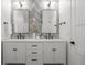 Bathroom with dual vanity, modern light fixtures, sleek mirrors, enhancing a stylish design with herringbone backsplash at 451 S Franklin St, Denver, CO 80209