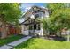 Charming two-story home featuring black and white trim, manicured lawn, and inviting walkway at 451 S Franklin St, Denver, CO 80209