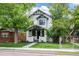 Charming two-story home featuring black and white trim, manicured lawn, and inviting walkway at 451 S Franklin St, Denver, CO 80209