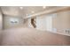 Finished basement area with neutral walls, a staircase, carpet, and a bright window at 19703 Serenity Springs Pt, Monument, CO 80132