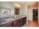 Bright bathroom featuring a double vanity, granite counters, and a view from the large sunny window at 19703 Serenity Springs Pt, Monument, CO 80132