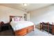 Well-lit bedroom boasts neutral paint, plush carpet, and a lovely wooden bed frame at 19703 Serenity Springs Pt, Monument, CO 80132