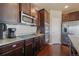 Modern kitchen with stainless steel appliances, granite countertops, and dark wood cabinets at 19703 Serenity Springs Pt, Monument, CO 80132