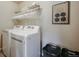 Functional laundry room with modern appliances, storage shelves, and convenient baskets at 19703 Serenity Springs Pt, Monument, CO 80132