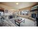 Open-concept living room with fireplace, large windows, and comfortable seating, flowing into the dining area at 19703 Serenity Springs Pt, Monument, CO 80132