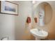 Modern powder room with pedestal sink, framed mirror, and tasteful decor, perfect for guests at 19703 Serenity Springs Pt, Monument, CO 80132