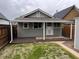View of the back of this gray home with a small deck and small grassy yard at 4875 Lowell Blvd, Denver, CO 80221