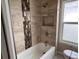 The updated bathroom features decorative tile and a shower-tub combination with built-in niche at 4875 Lowell Blvd, Denver, CO 80221