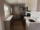 Modern kitchen featuring stainless steel appliances, light countertops, updated cabinetry, and wood-look flooring at 4875 Lowell Blvd, Denver, CO 80221