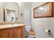 Cozy bathroom has a wooden cabinet and decorative commode seat at 5129 S Tom Bay Rd, Bennett, CO 80102