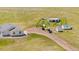 Aerial shot of the ranch-style house, showcasing the outbuildings at 5129 S Tom Bay Rd, Bennett, CO 80102