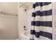 Bright bathroom featuring a white tiled shower and a navy striped shower curtain at 22520 E Ontario Dr # 101, Aurora, CO 80016