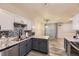 Kitchen with grey cabinets, stone countertops, stainless steel appliances, and adjacent eating area at 22520 E Ontario Dr # 101, Aurora, CO 80016