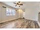 Bright living room showcasing wood-look flooring, neutral walls, a ceiling fan, and natural light from the large window at 22520 E Ontario Dr # 101, Aurora, CO 80016