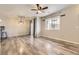 Open-concept living room featuring wood-look flooring, neutral walls, and an adjacent dining area with an elegant chandelier at 22520 E Ontario Dr # 101, Aurora, CO 80016