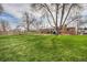 Expansive fenced backyard featuring a well-maintained lawn and mature trees, perfect for outdoor activities and relaxation at 3937 W Grand Ave, Littleton, CO 80123