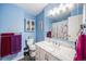 Bright bathroom featuring blue walls, shower with floral curtain, and vanity with marble countertop at 3937 W Grand Ave, Littleton, CO 80123