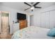 Neutral bedroom with ceiling fan, TV, dresser, and a view into the adjacent bathroom at 3937 W Grand Ave, Littleton, CO 80123