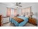 Bedroom featuring a bed with colorful quilt, side tables, and natural light through patterned curtains at 3937 W Grand Ave, Littleton, CO 80123