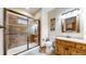 Well-lit bathroom with stand-up shower featuring decorative tile and a modern wooden vanity at 4456 Mohawk Dr, Larkspur, CO 80118
