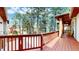 Inviting deck with wooden railings, overlooking a private yard and mature trees at 4456 Mohawk Dr, Larkspur, CO 80118