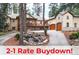Beautiful home exterior featuring a stone facade, wood garage doors, deck, and water feature in a wooded setting at 4456 Mohawk Dr, Larkspur, CO 80118