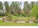 Secluded home surrounded by lush forest and front yard with a decorative water feature and wood fence at 4456 Mohawk Dr, Larkspur, CO 80118