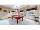 Basement game room featuring a classic billiard table and two bright windows at 4456 Mohawk Dr, Larkspur, CO 80118
