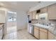 Well-lit kitchen with tile countertops, a window, a double sink and updated appliances at 7329 S Jay St, Littleton, CO 80128