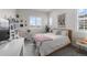 Cozy bedroom featuring a bed with a pink throw, natural light, and modern decor at 5625 Heritage Oak Dr, Parker, CO 80134