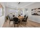 Dining room with hardwood floors, modern light fixture, artwork, and a view into the kitchen at 5625 Heritage Oak Dr, Parker, CO 80134
