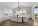 Bright dining room features wood floors, white chairs, plantation shutters, and an elegant light fixture at 5625 Heritage Oak Dr, Parker, CO 80134