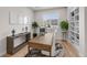 Home office featuring hardwood floors, modern desk, built-in shelves, and a large window at 5625 Heritage Oak Dr, Parker, CO 80134