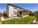 Spacious backyard featuring a manicured lawn and covered patio area at 14437 Grape St, Thornton, CO 80602