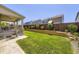 Lush backyard with a well-maintained lawn, retaining wall, and covered patio at 14437 Grape St, Thornton, CO 80602