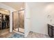 Modern bathroom featuring a tiled shower with glass doors and neutral-toned flooring at 14437 Grape St, Thornton, CO 80602