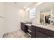 Modern bathroom featuring dual sinks, granite countertops, and large mirrors at 14437 Grape St, Thornton, CO 80602