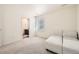 Bright bedroom with a view, neutral walls, carpeted floor, and a white sectional sofa and ottoman at 14437 Grape St, Thornton, CO 80602