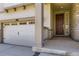 Close-up of home showcasing the garage door, front door, and porch with stone accents at 14437 Grape St, Thornton, CO 80602
