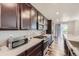 Modern kitchen with stainless steel appliances, dark cabinets, and stylish backsplash at 14437 Grape St, Thornton, CO 80602