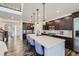 Spacious kitchen with dark wood cabinets, a large island with quartz countertops, and modern stainless steel appliances at 14437 Grape St, Thornton, CO 80602