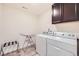 Functional laundry room with washer, dryer, and cabinet storage at 14437 Grape St, Thornton, CO 80602