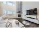 Bright living room featuring a fireplace, modern furniture, and large windows at 14437 Grape St, Thornton, CO 80602