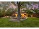 Evening shot of backyard with patio, outdoor dining, fire pit, and mature trees at 6248 S Coventry Ln, Littleton, CO 80123